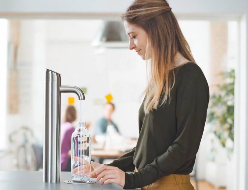 Frau holt sich eine Flasche Wasser aus dem Brita Extra-I-Tap